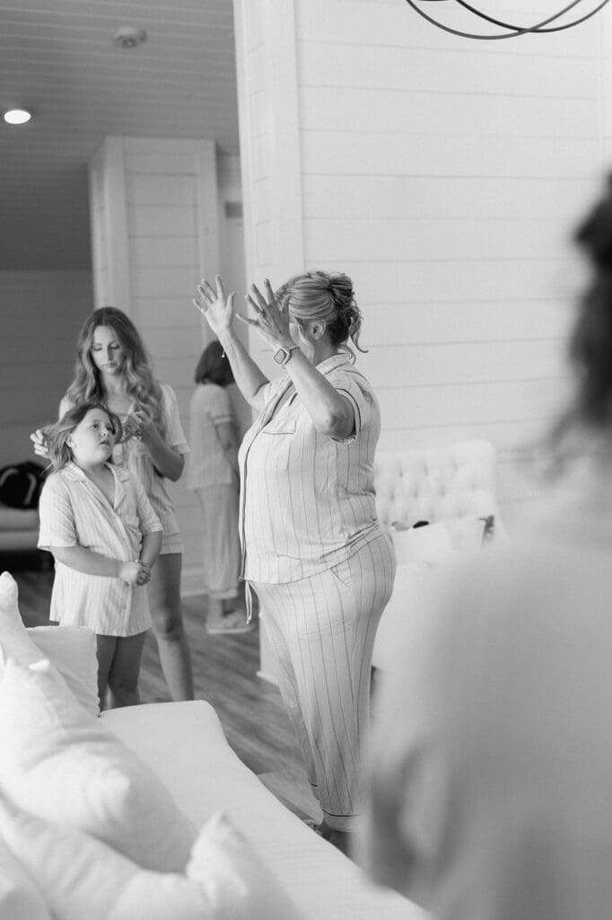 Black and white photo of brides mom doing a prayer in the bridal suite at The Farmhouse