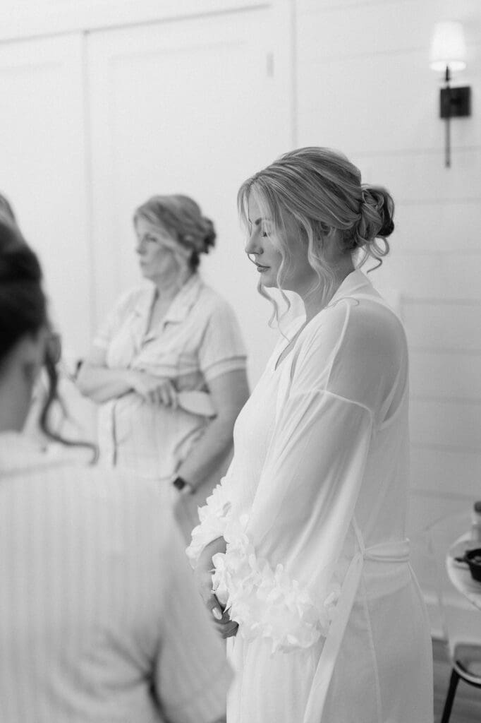 Black and white of bride in prayer in the bridal suite at The Farmhouse