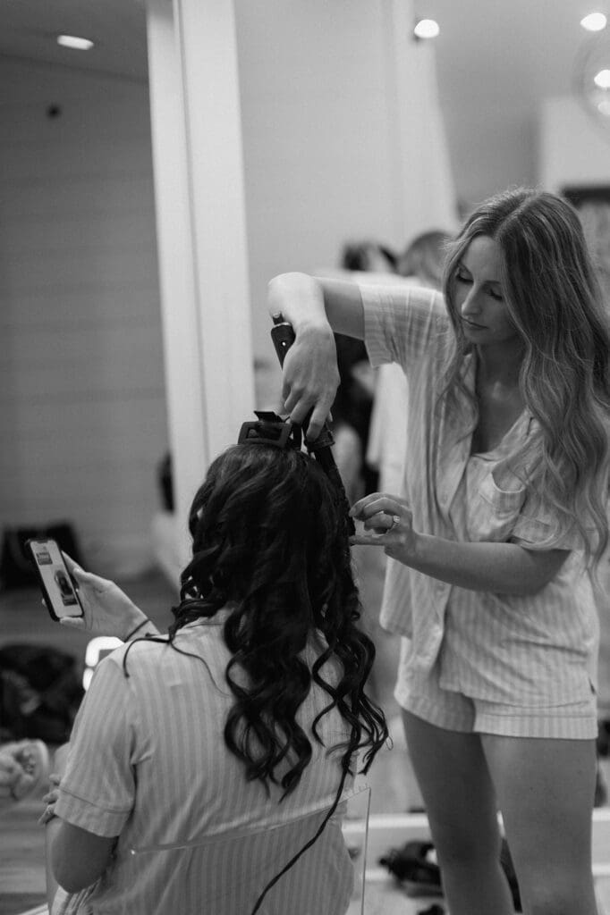 Black and white portrait of bridesmaids doing hair and make up in the bridal suite at The Farmhouse