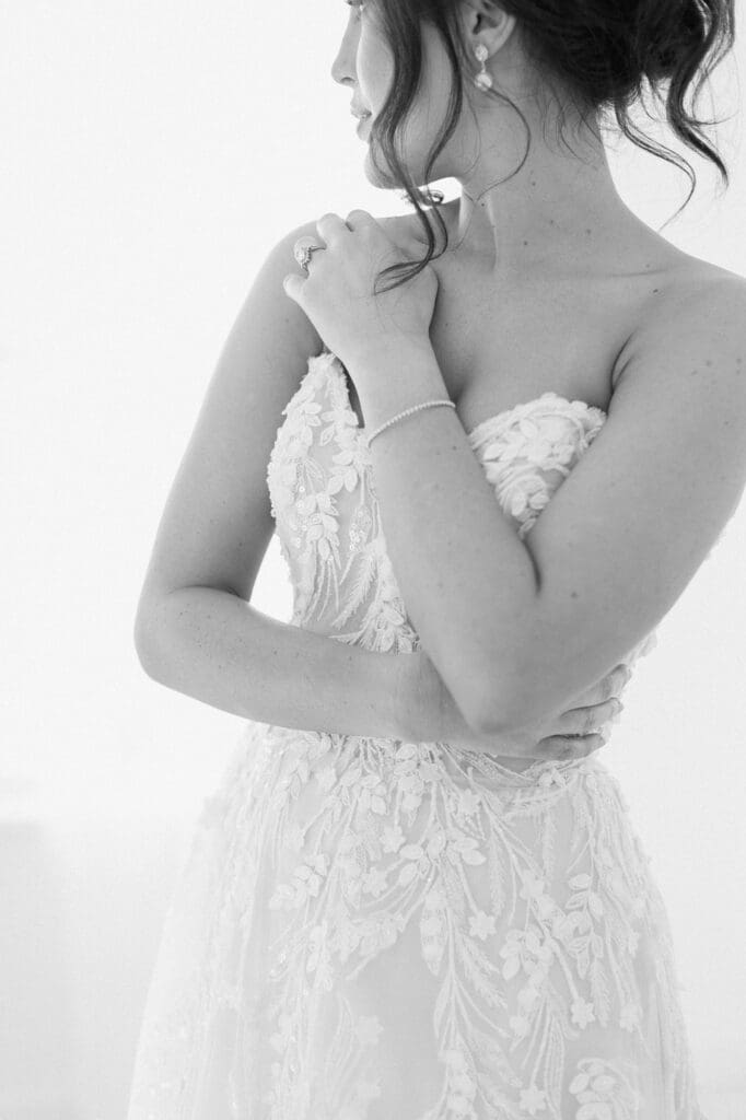 Close up black and white portrait of bride looking away and hugging her body