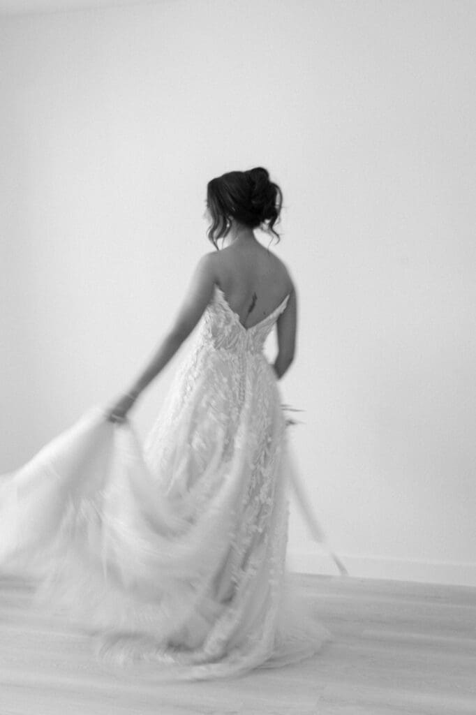 Black and white portrait of bride spinning in her dress with a slight blur