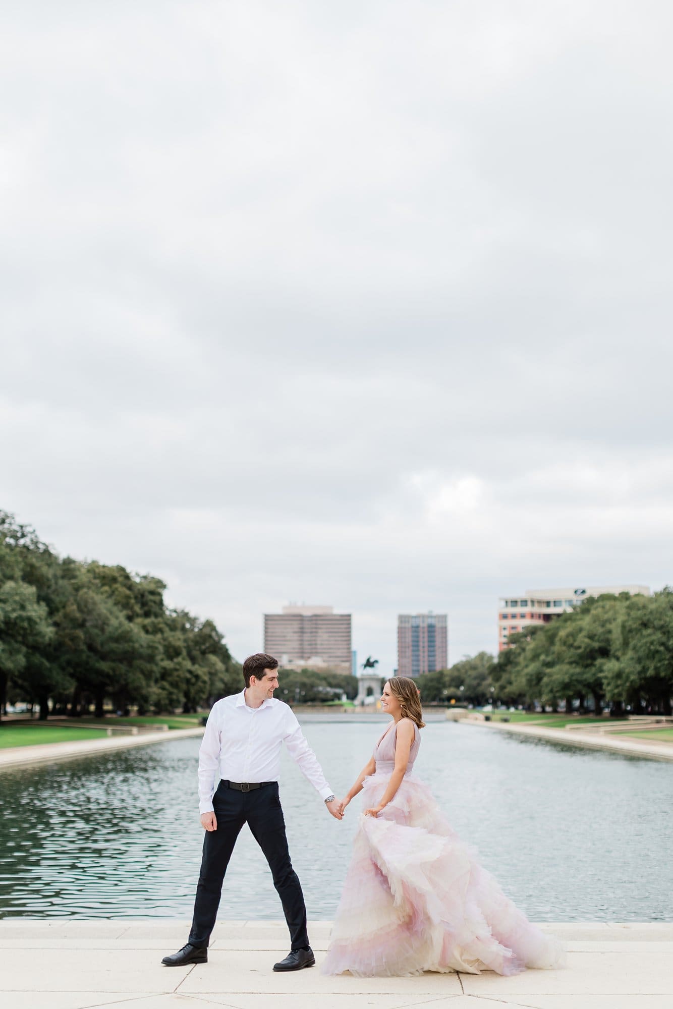 Couple walking in front of the water at Hermann park for their engagement session