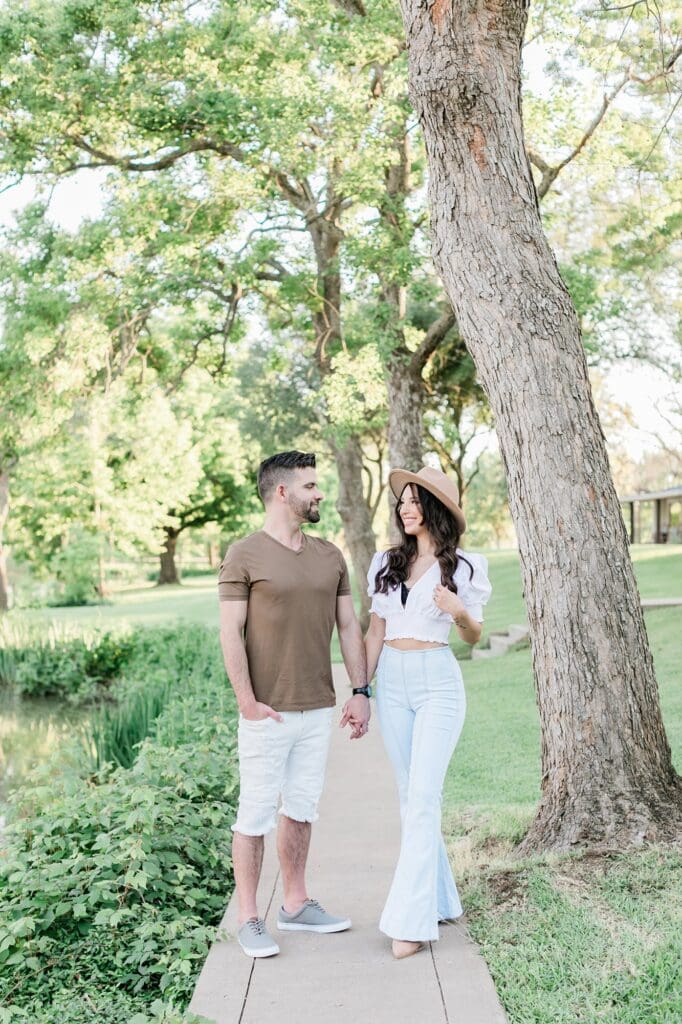 Bride and groom smiling at each other under the trees for their orchard at caney creek engagement session