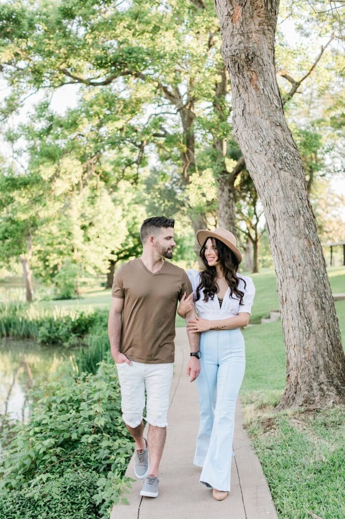 bride and groom walking by the pond for their orchard at caney creek engagement session