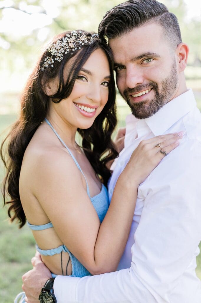 Couple smiling at the camera for their engagement session at the orchard at caney creek