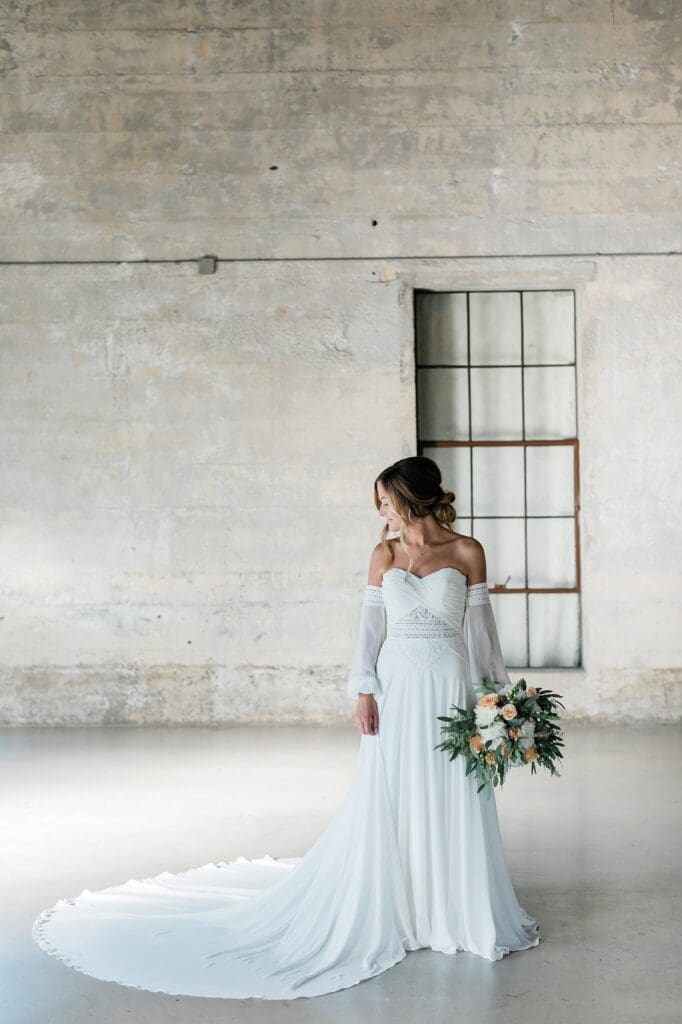Bride looking down at her train for her bridal portraits at Olde Dobbin Station