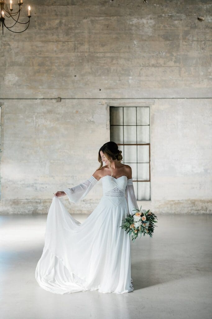 Bride playing with her train for her bridal portraits at Olde Dobbin Station