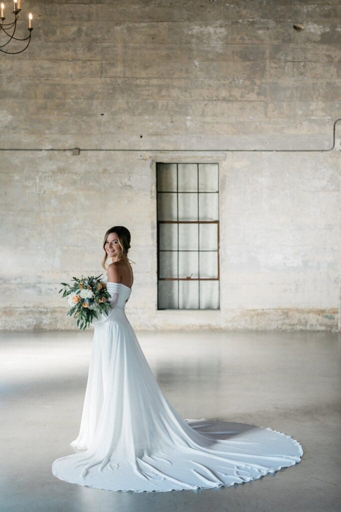 Bride looking back at the camera holding her bouquet for her bridals at Olde Dobbin Station
