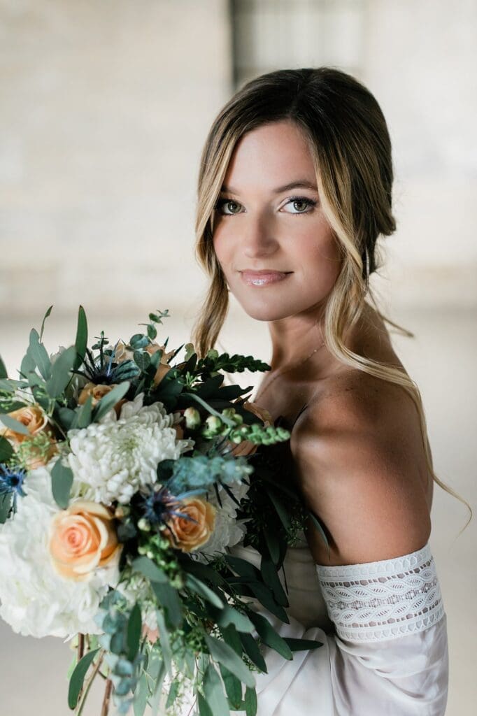 Up close of bride smiling at the camera holding her bouquet for her bridals at Olde Dobbin Station