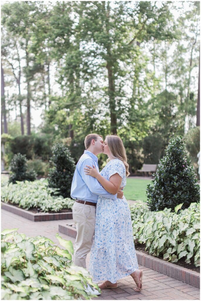 Intimate candid moment of engaged couple surrounded by greenery in Houston TX