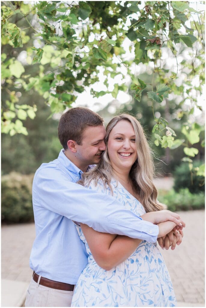 Intimate candid moment of engaged couple surrounded by greenery in Houston TX