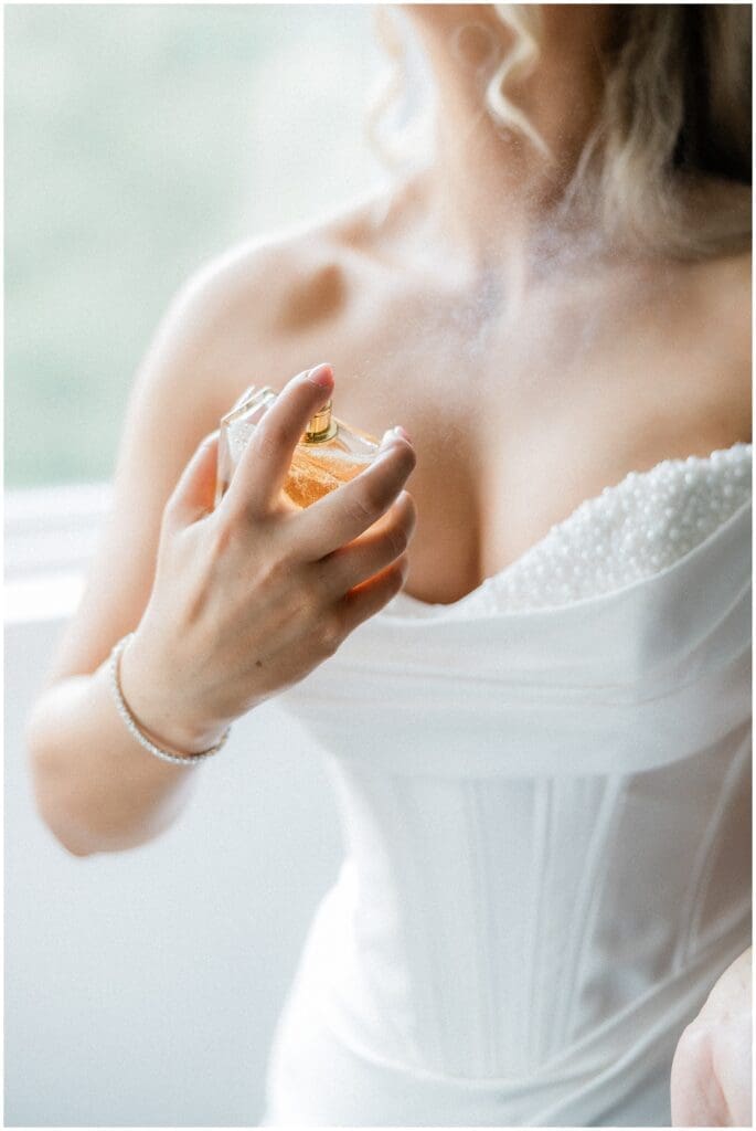Bride putting on perfume in the bridal suite at Addison Woods
