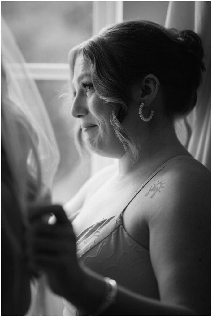 Bridesmaids crying while helping bride get dressed at Addison Woods