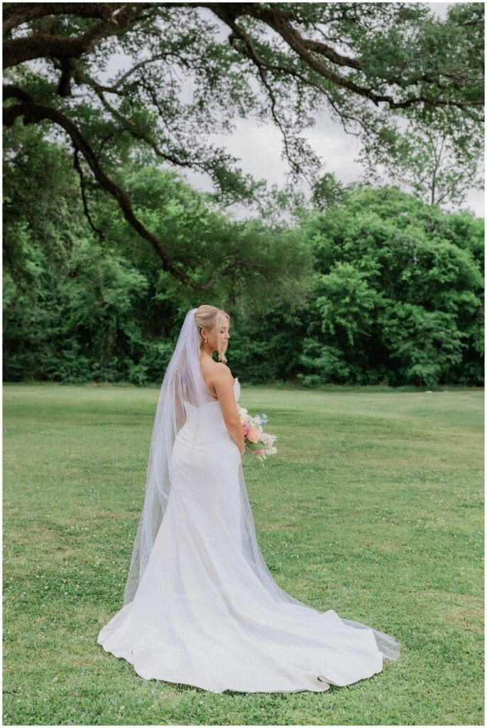 Bride standing under the Oak tree for bridal portraits at Addison Woods
