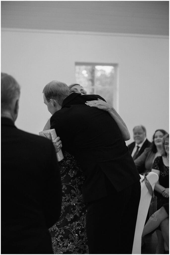 Groom hugging his mother during ceremony at Addison Woods