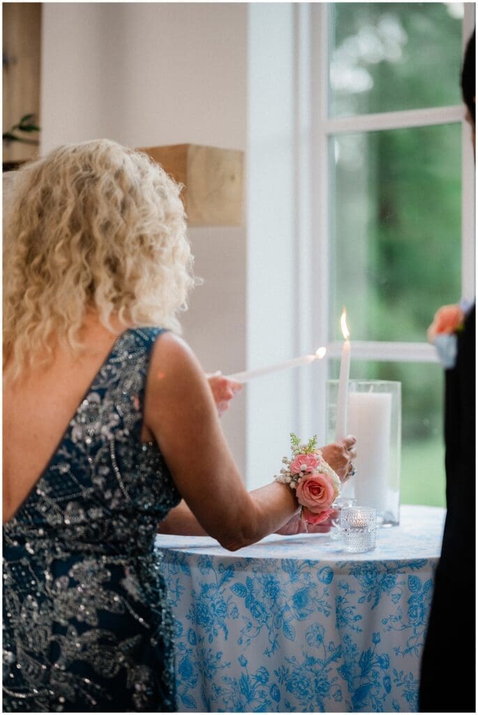 Mother of the bride and mother of the groom lighting the unity candle during the ceremony at Addison Woods