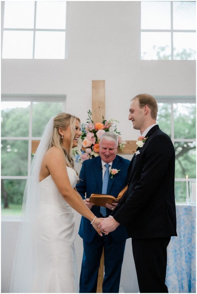 Bride and groom laughing with each other during their ceremony at Addison Woods