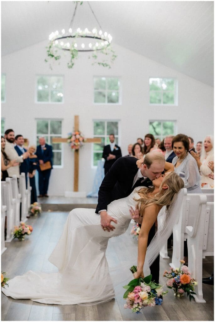 Groom dipping bride for a kiss at Addison Woods