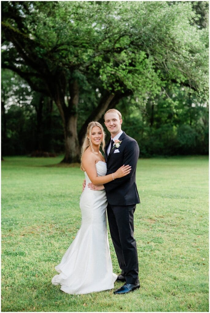 Bride and groom smiling together under the oak tree at Addison Woods