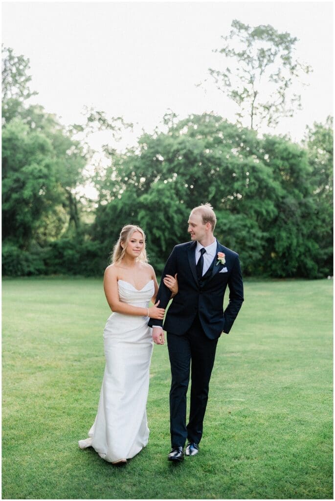 Bride and groom walking under the oak tree at Addison Woods