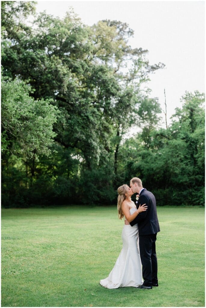 Bride and groom kissing under the oak tree at Addison Woods