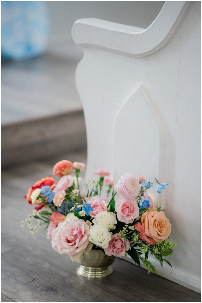 Colorful florals in a gold vase lining the chapel floors at Addison Woods
