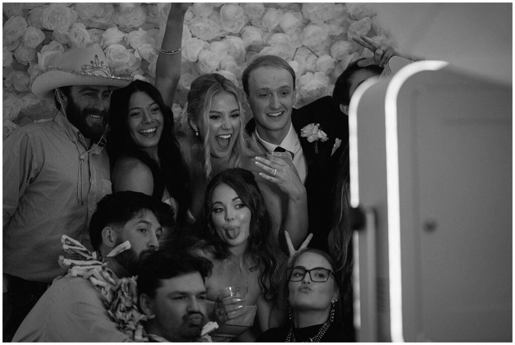 Bride and groom taking a photo at the photo booth with guests at Addison Woods