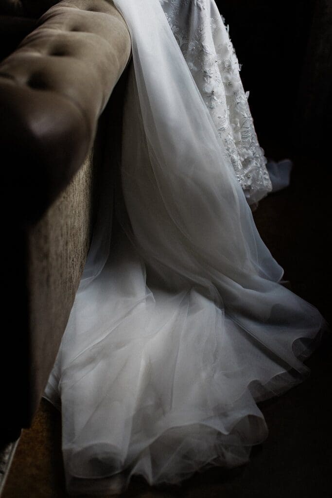 Brides train and veil draped over a couch at iron manor
