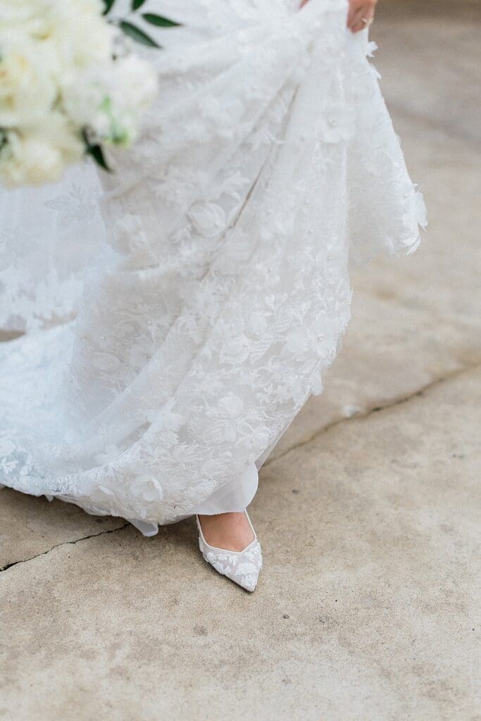 Bride holding up her dress and showing off her shoes at Iron Manor
