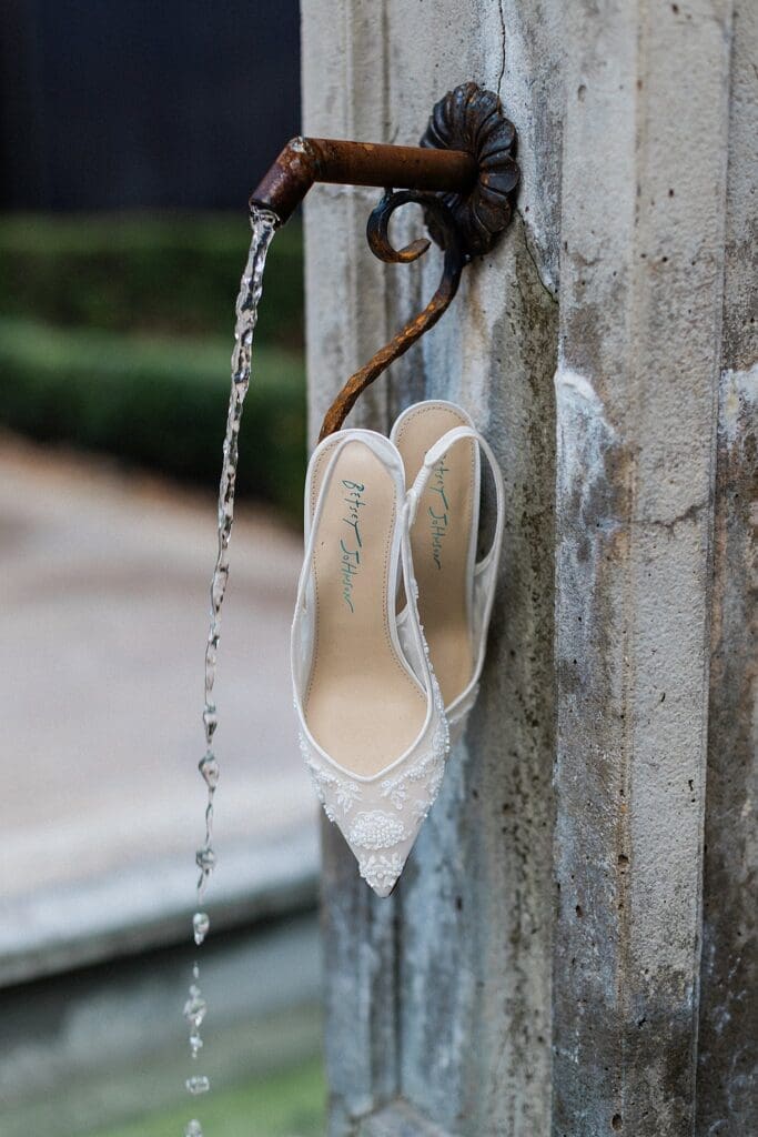 Bride's shoes hanging from a fountain at Iron Manor