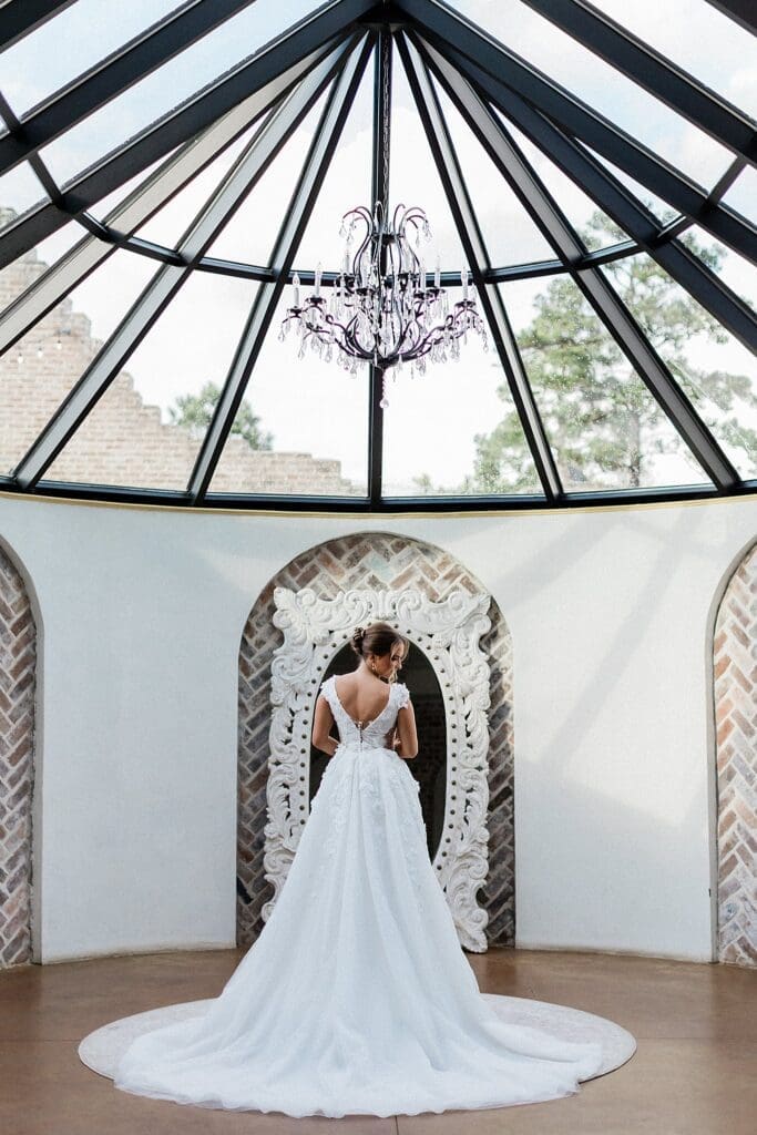 Bride standing looking back at her train in the bridal suite at iron manor
